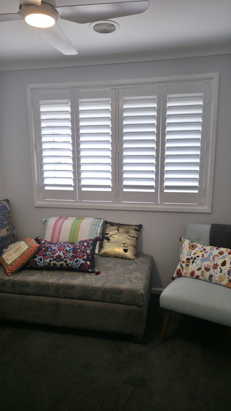 Sitting room bay window with crisp white plantation shutters